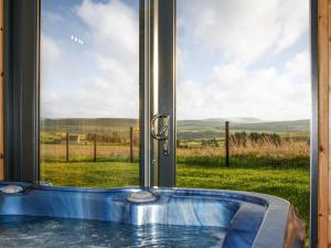 a tub in front of a window with a view of a field at Ben Rinnes - Ukc6028 in Newmill +2 photos