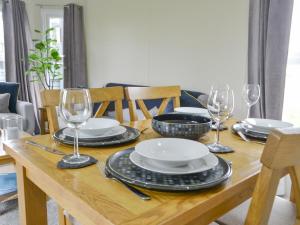 a wooden table with plates and wine glasses on it at Unwind 37 - Uk43980 in West Thirston