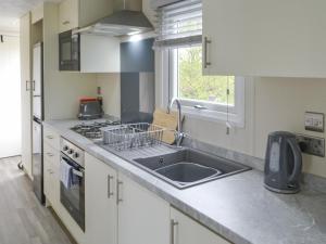 a kitchen with a sink and a stove at Unwind 37 - Uk43980 in West Thirston +12 photos