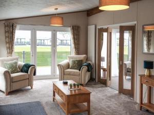 a living room with two chairs and a table at Rivendale 76 in St. Andrews
