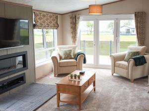 a living room with a fireplace and a tv at Rivendale 76 in St. Andrews
