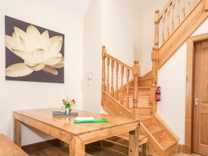 a room with a wooden table and stairs at Appletree Cottage - Ukc6251 in Linlithgow