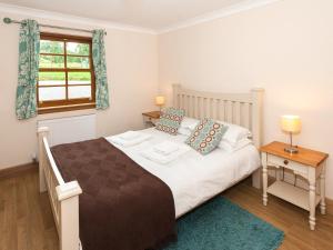 a bedroom with a large bed and a window at Appletree Cottage - Ukc6251 in Linlithgow +4 photos