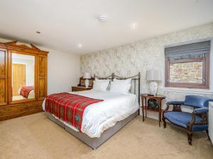 a bedroom with a bed and a chair and a window at The Servant's Hall - Ukc6964 in Carnoustie