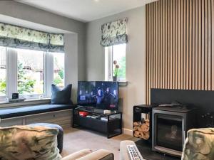 a living room with a fireplace and a tv at Snowy Owl Lodge-Ukc5065 in Aviemore