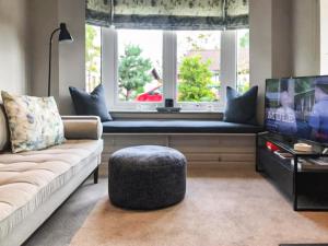 a living room with a couch and a tv and a window at Snowy Owl Lodge-Ukc5065 in Aviemore