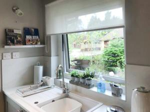a kitchen with a sink and a window at Snowy Owl Lodge-Ukc5065 in Aviemore +10 photos