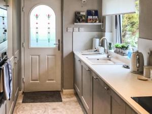 a kitchen with a white door and a sink at Snowy Owl Lodge-Ukc5065 in Aviemore