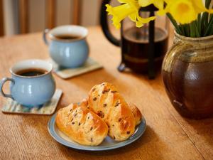 two loaves of bread on a plate next to two cups of coffee at Fishermans's Rest in Lossiemouth