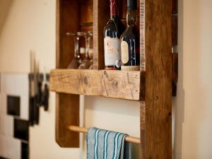 a wooden shelf with bottles of wine on it at Fishermans's Rest in Lossiemouth