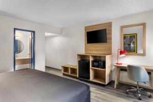 a hotel room with a bed and a desk and a tv at Super 8 by Wyndham Chicago IL in Chicago