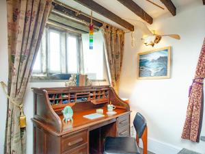 a desk and chair in a room with a window at The North Wing - Ukc6794 in Saint Gennys +20 photos
