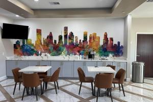 a restaurant with two tables and a painting on the wall at Super 8 by Wyndham Baytown in Baytown +17 photos