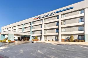 a large white building with a sign on it at Baymont by Wyndham Arlington At Six Flags Dr in Arlington