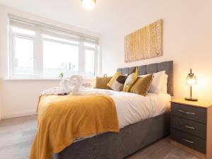 a bedroom with a large bed with a yellow blanket at Flat 1-Uk41147 in Southampton