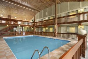 a large swimming pool in a hotel with a building at Days Inn by Wyndham Vernon in Vernon