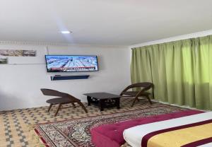 a hotel room with two beds and a tv on the wall at Hotel Green Town Port Dickson in Port Dickson