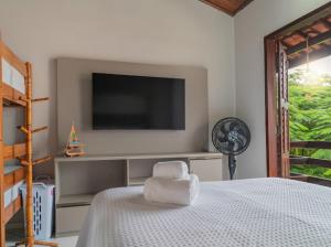 a bedroom with a flat screen tv and a bed at Flat dboa in Jericoacoara