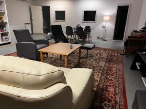 a living room with a couch and tables and chairs at Whaletours Center Apartment in Ilulissat +4 photos