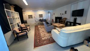 a living room with a white couch and chairs at Whaletours Center Apartment in Ilulissat