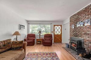 a living room with a couch and chairs and a brick wall at Riverkern Retreat House in Kernville