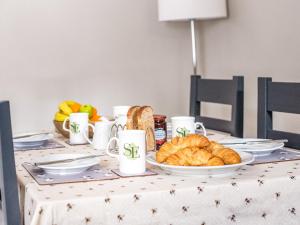 a table with croissants and a plate of bread at Symond House-Ukc5530 in Bury Saint Edmunds