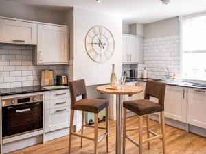 a kitchen with a table and chairs in it at Symond House-Ukc5530 in Bury Saint Edmunds