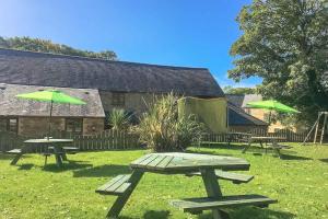 two picnic tables with green umbrellas in a yard at Fistral Cottage - Cwc46839 in Perranporth +18 photos