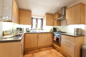 a kitchen with wooden cabinets and a sink at Fistral Cottage - Cwc46839 in Perranporth