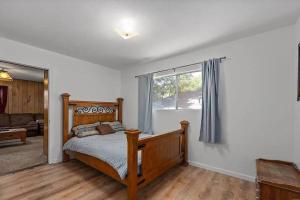 a bedroom with a wooden bed and a window at Riverkern Retreat House in Kernville