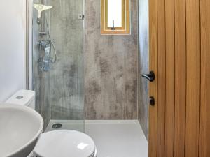 a bathroom with a shower with a toilet and a sink at Hornbeam - Uk44262 in Waldron
