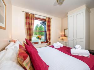 a bedroom with a large white bed with red pillows at Munro View - Ukc5040 in Aviemore +6 photos