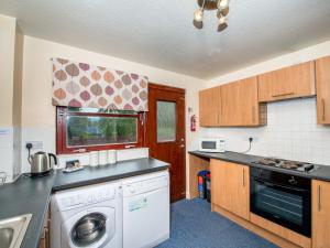 a kitchen with a washer and dryer in it at Munro View - Ukc5040 in Aviemore