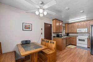 a kitchen with a wooden table and a ceiling fan at Riverkern Retreat House in Kernville