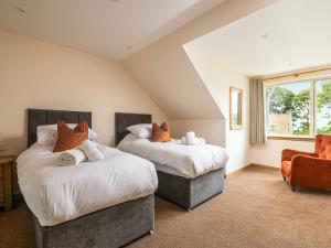 a bedroom with two beds and a chair at Selkirk Lodge - Ukc5803 in Lundin Links