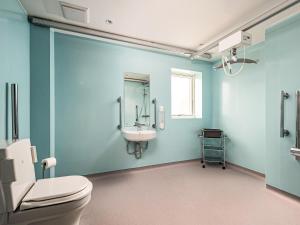 a blue bathroom with a toilet and a sink at Selkirk Lodge - Ukc5803 in Lundin Links +2 photos