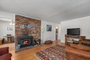 a living room with a brick wall and a fireplace at Riverkern Retreat House in Kernville +3 photos