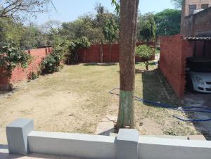 a yard with a tree and a fence at Thakur Shri Dwarkadhish Seva Sadan in Mathura +7 photos