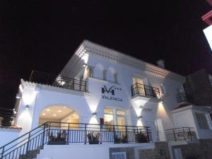 a white building with a sign on it at night at Hôtel Valencia in Hendaye