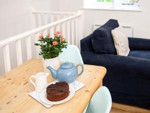 a table with a cake and a tea pot on it at Number Seven - Ukc4969 in Tawstock