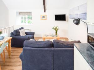 a living room with two blue couches and a table at Number Seven - Ukc4969 in Tawstock