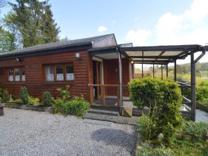 a log cabin with a porch and a roof at Comfortable chalet in PetitHan with garden in Durbuy