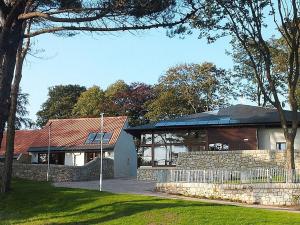 a house with a building with a fence in front of it at Homelands-Keil in Lundin Links +2 photos