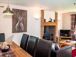a dining room with a table and chairs and a fireplace at The Stag-Ukc5066 in Aviemore