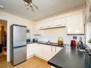 a kitchen with white cabinets and a stainless steel refrigerator at The Stag-Ukc5066 in Aviemore +8 photos