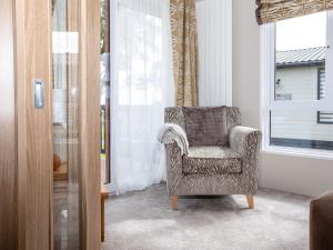 a chair sitting in a room with a window at Rivendale in St. Andrews +14 photos