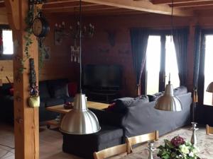 a living room with a couch and two lights at Magnificent chalet on the mountain slopes in Les Gets