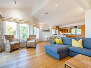 a living room with a blue couch and a table at Wrens Lake House in South Cerney