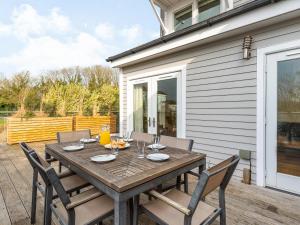 a wooden table and chairs on a patio at Wrens Lake House in South Cerney