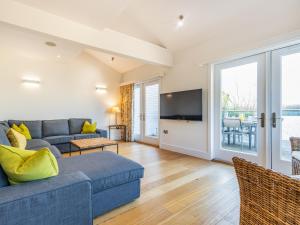 a living room with a couch and a tv at Wrens Lake House in South Cerney